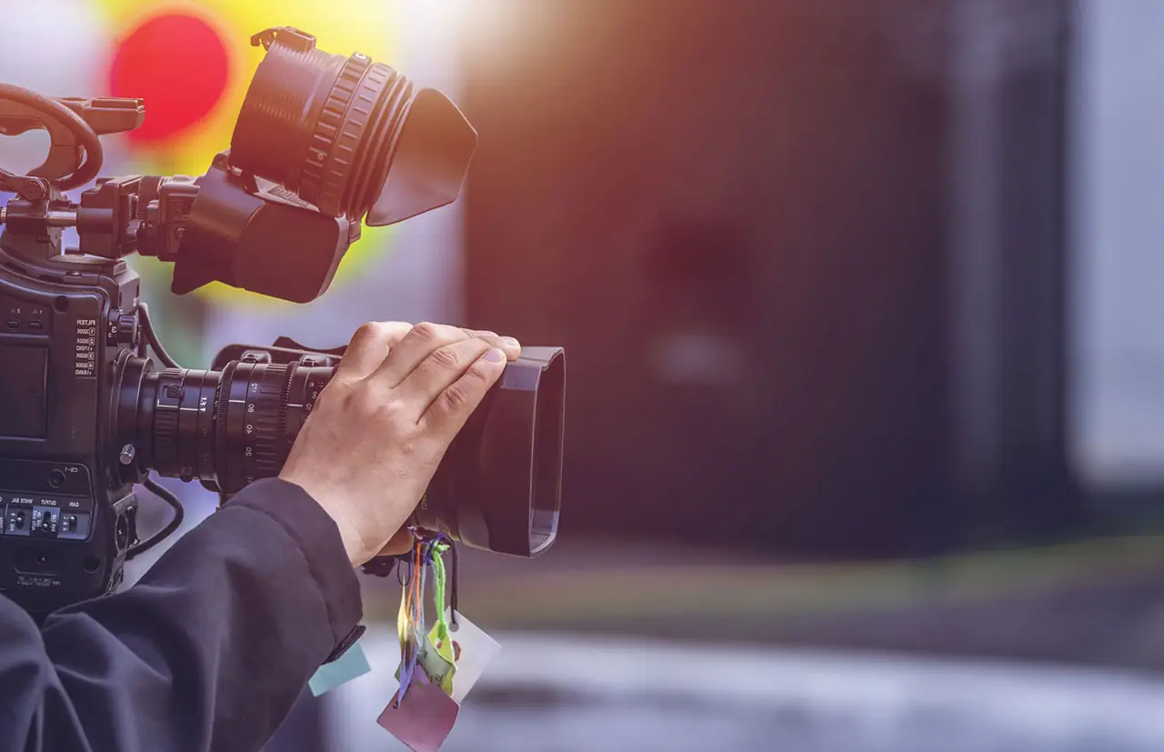 Broadcast video camera operator filming on location